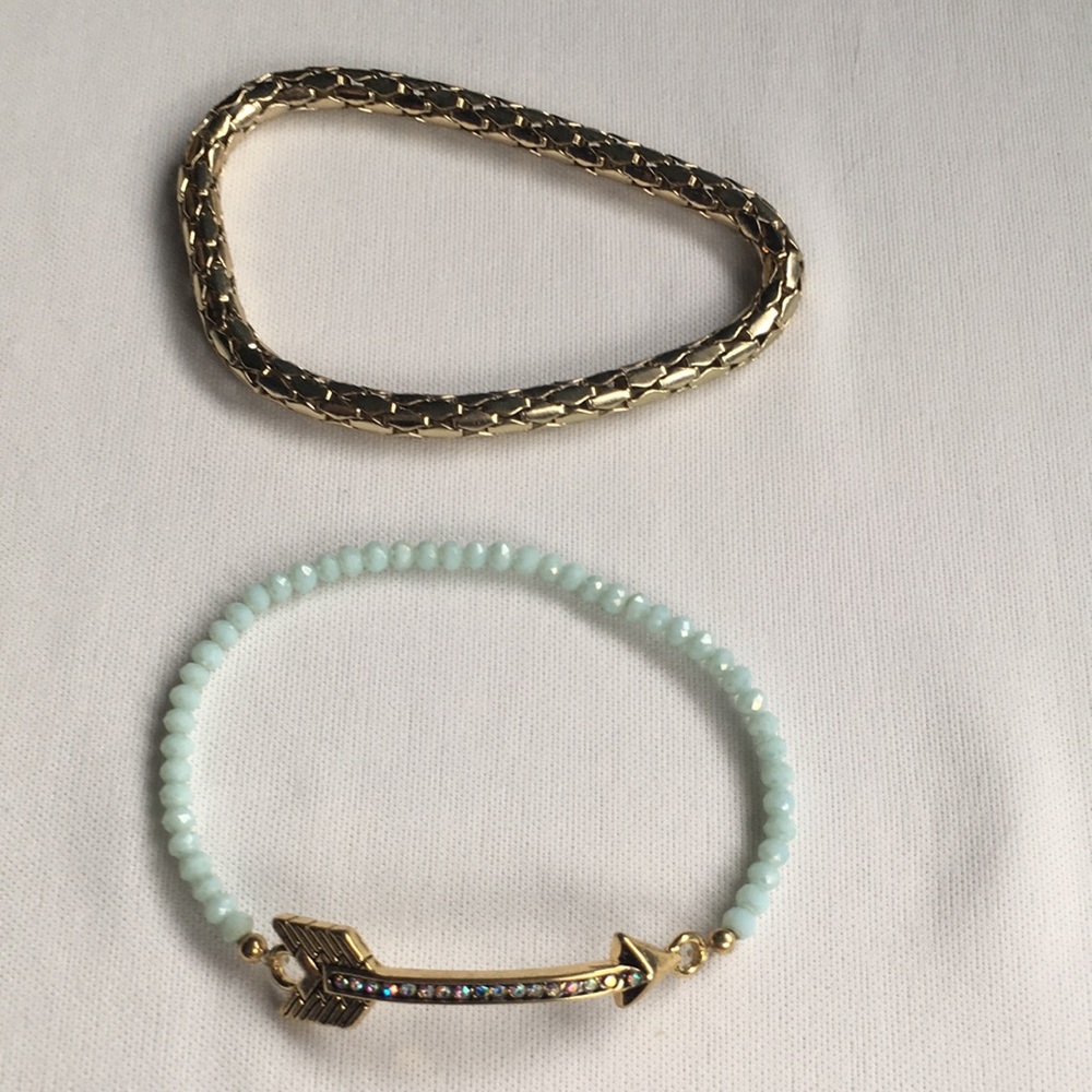 2 bracelets. Gold toned and arrow with rhi…